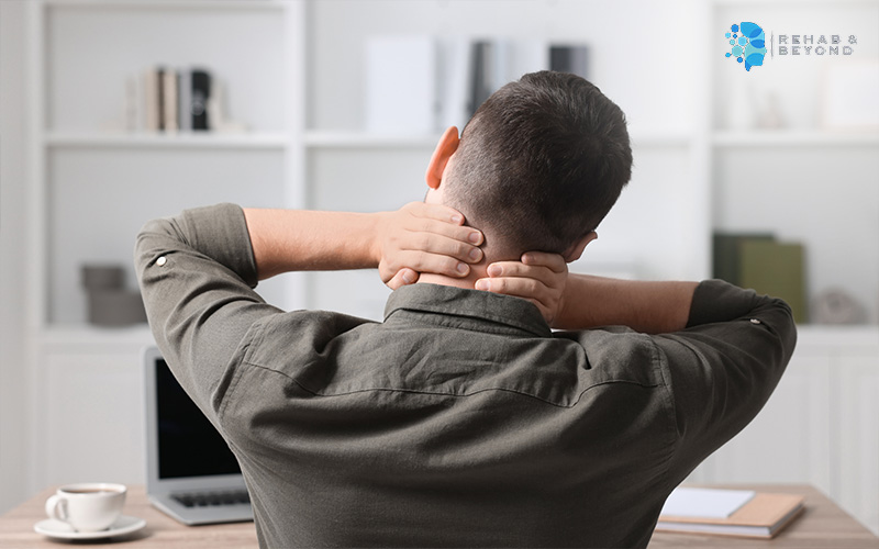 A person experiencing stiff neck from sitting still