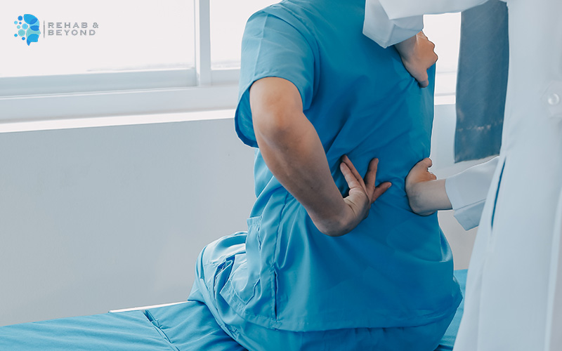 Doctor examining a pain point on patient's back